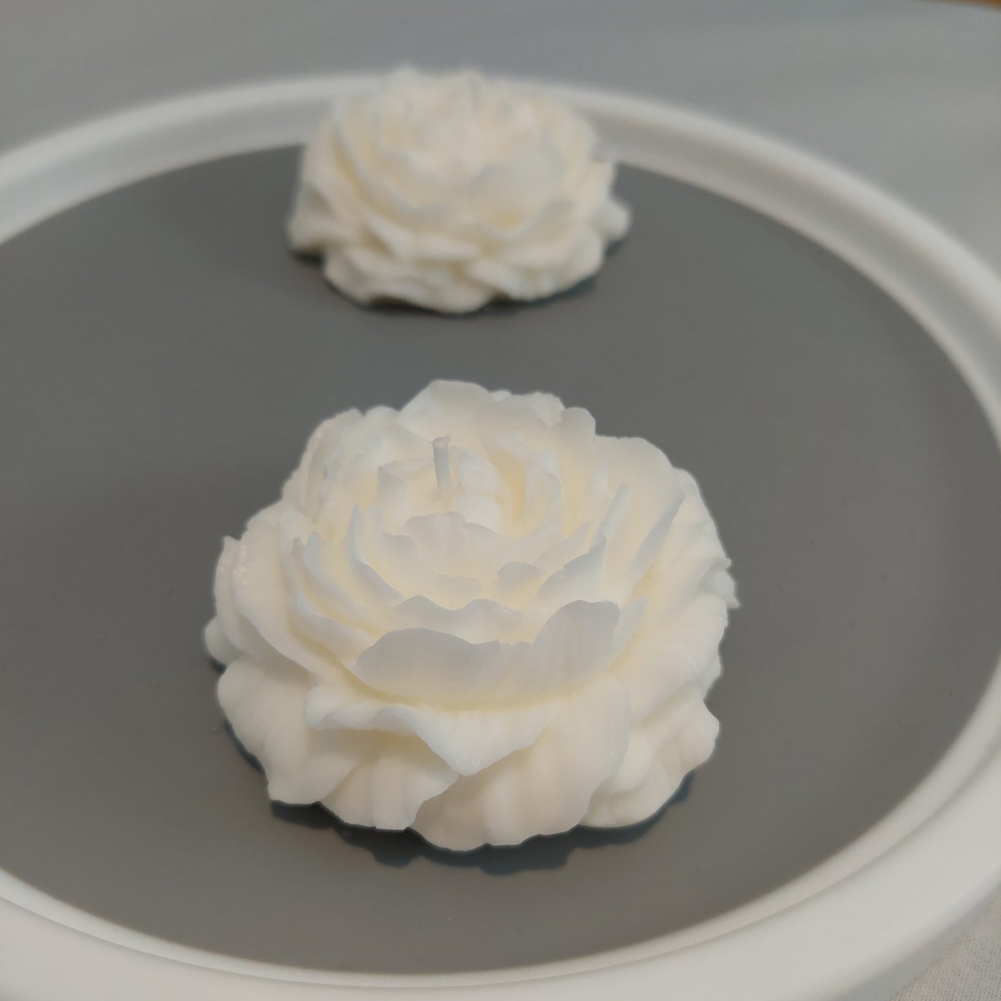 Perspective view of 2 white Peony Flower Candle