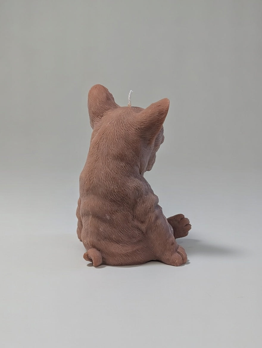 The back side of brown plush French Bulldog candle on a light grey background