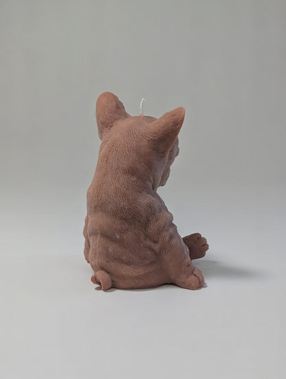 The back side of brown plush French Bulldog candle on a light grey background