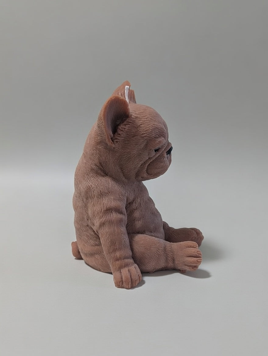 The side profile of a brown plush French Bulldog candle on a light grey background
