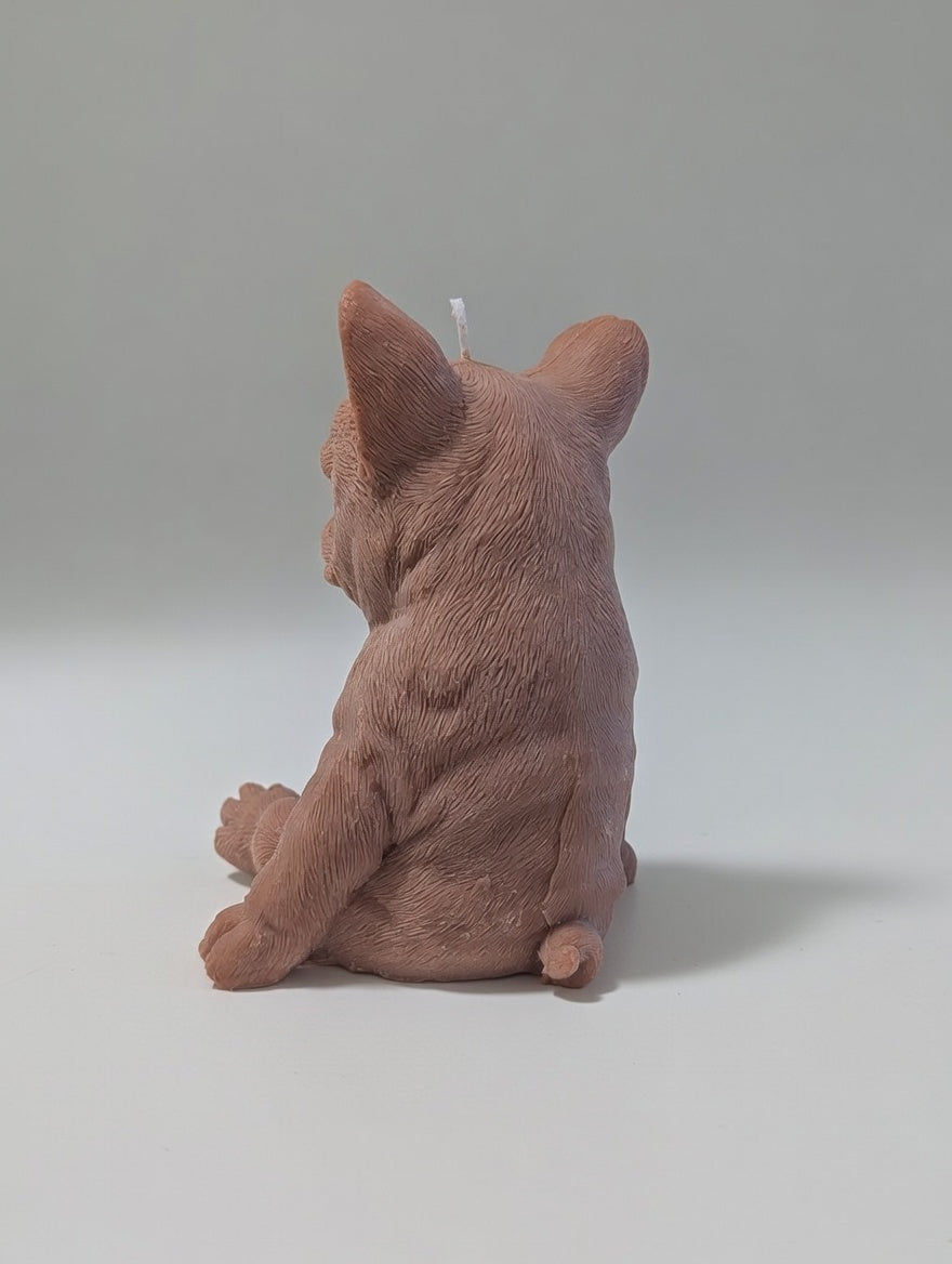 Quarter turn brown plush French Bulldog candle on a light grey background
