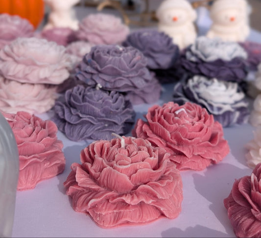 Decorative candles shaped like flowers in various colors on a table.