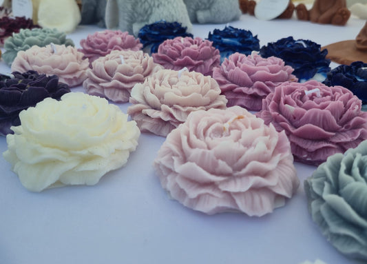 Colorful flower-shaped cakes on a table with teddy bears in the background