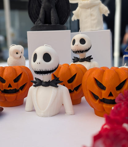 Night Mare Before Christmas Halloween-themed decorations including ghost figurines and jack-o'-lanterns on a table.