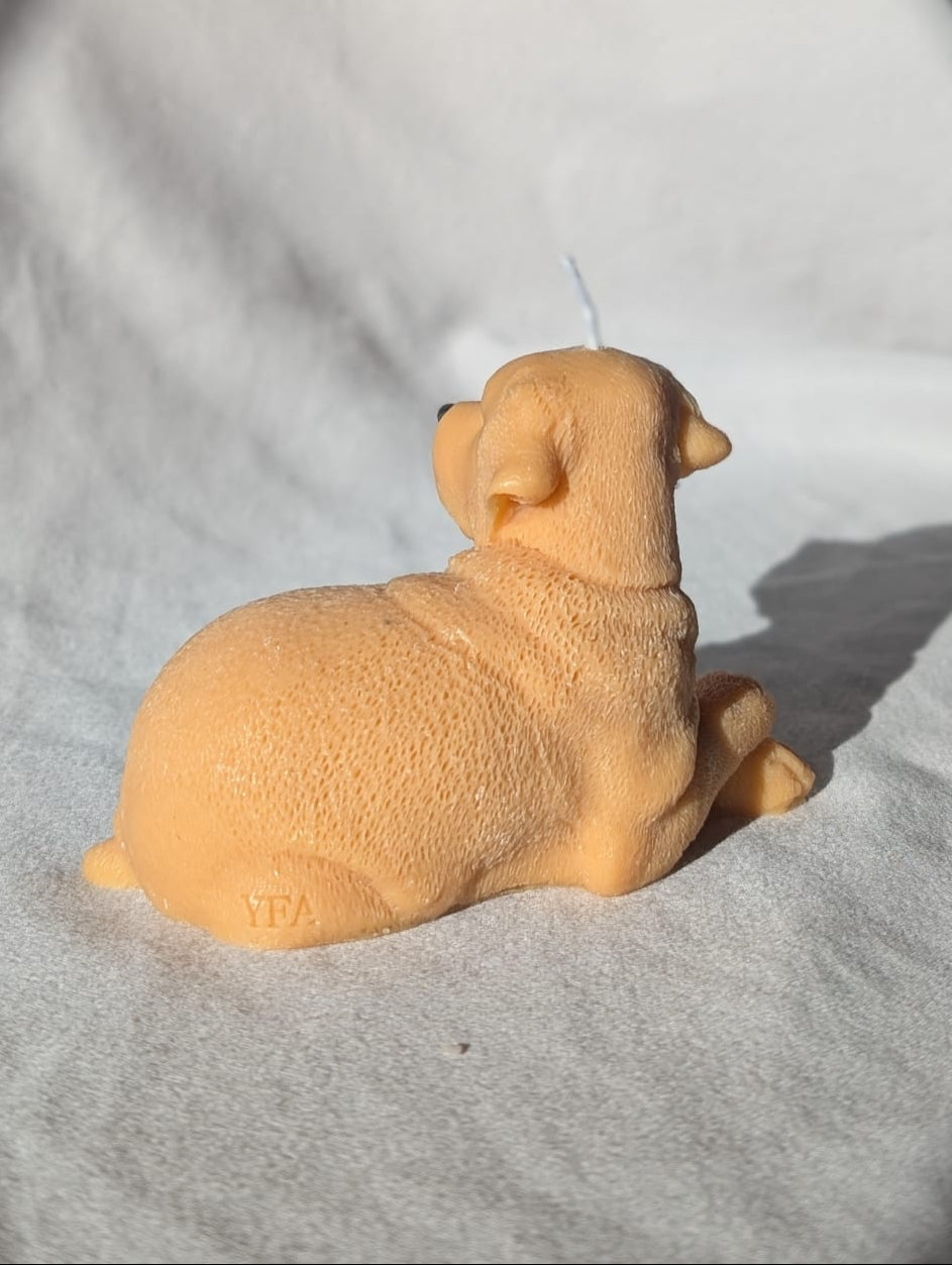 Labrador Retriever- shaped figurine on a gray surface with a blurred background