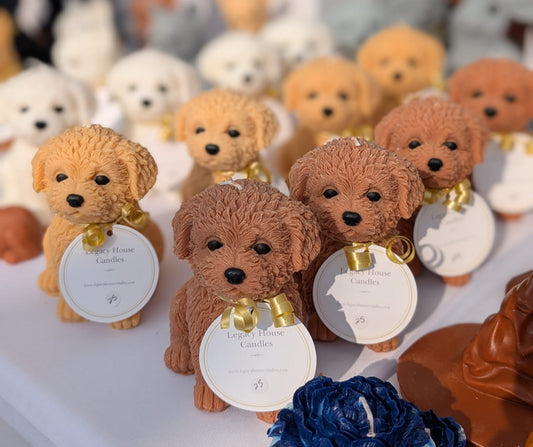 Collection of small Puppy figurine soy wax candles with labels on a table.