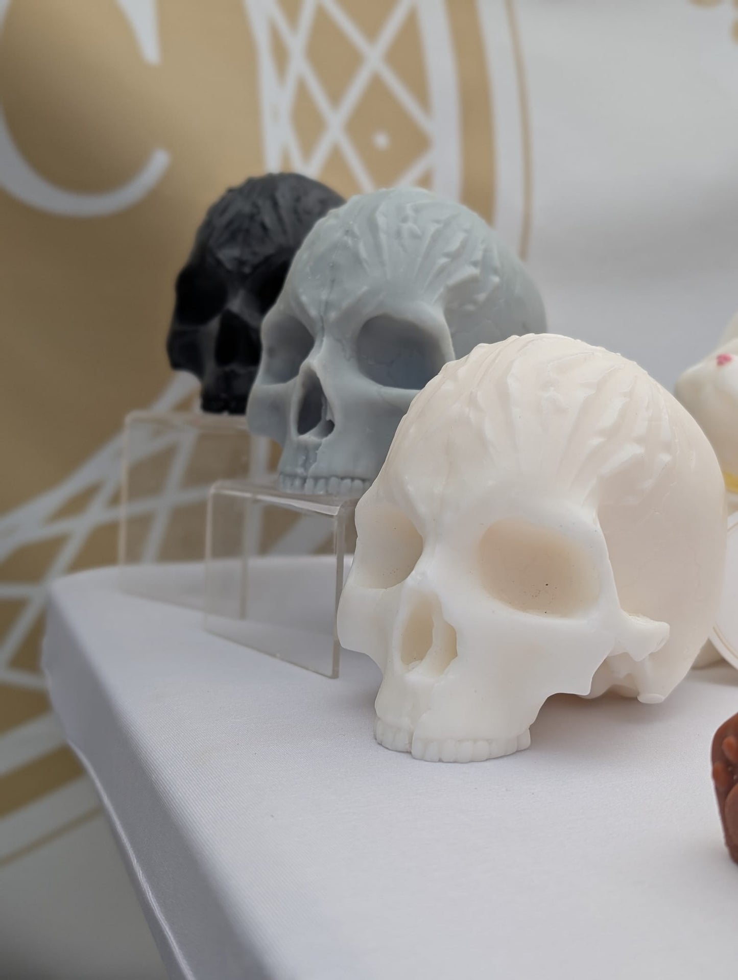 Skull-shaped objects on a white surface with a blurred background