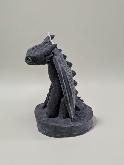 Black toothless figurine candle on a gray background