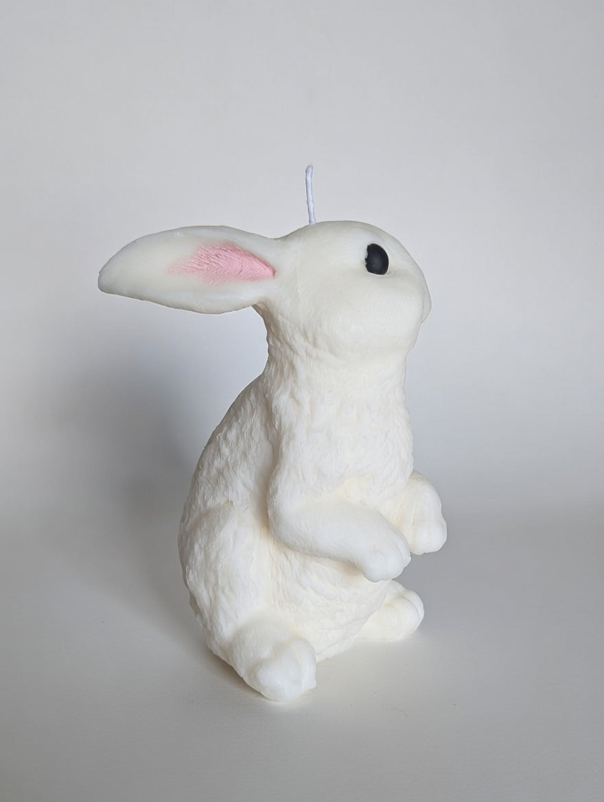 White rabbit-shaped candle on a light gray background
