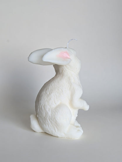 White rabbit-shaped candle on a light gray background