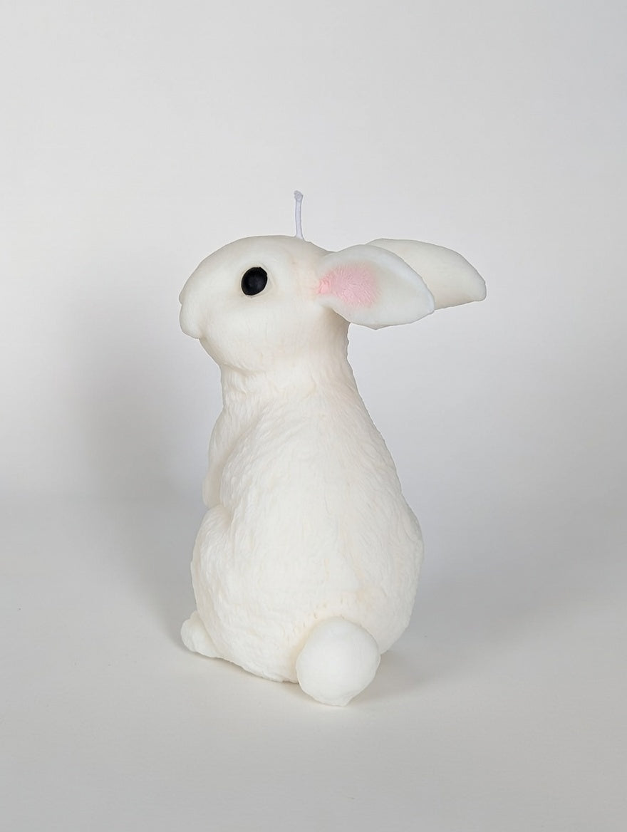 White rabbit-shaped candle on a light gray background