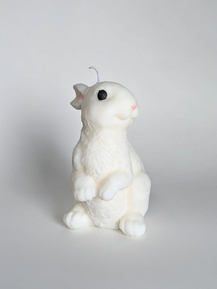 White rabbit-shaped candle on a light gray background